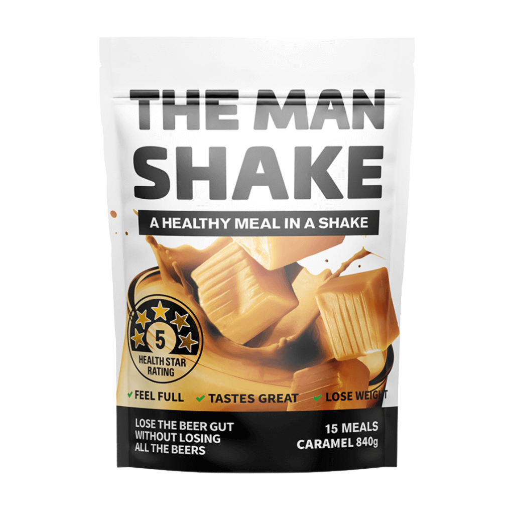 A prepared glass of The Man Shake meal replacement powder with ingredients in the background