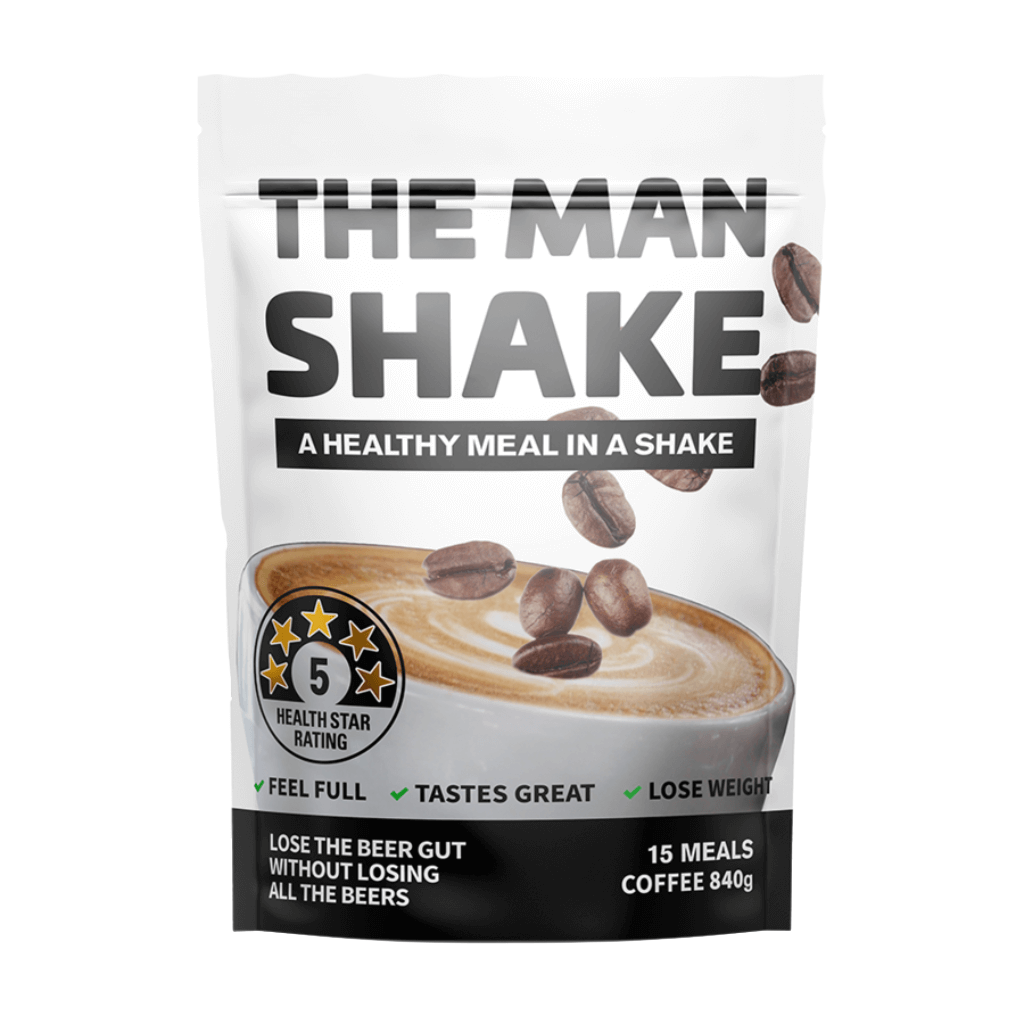 A prepared glass of The Man Shake meal replacement powder with ingredients in the background